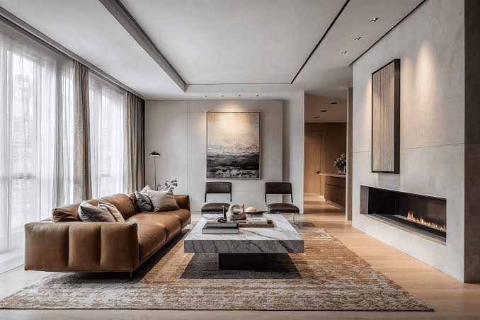 Modern living room featuring a brown sofa, marble table, two chairs, wall art, and built-in fireplace.