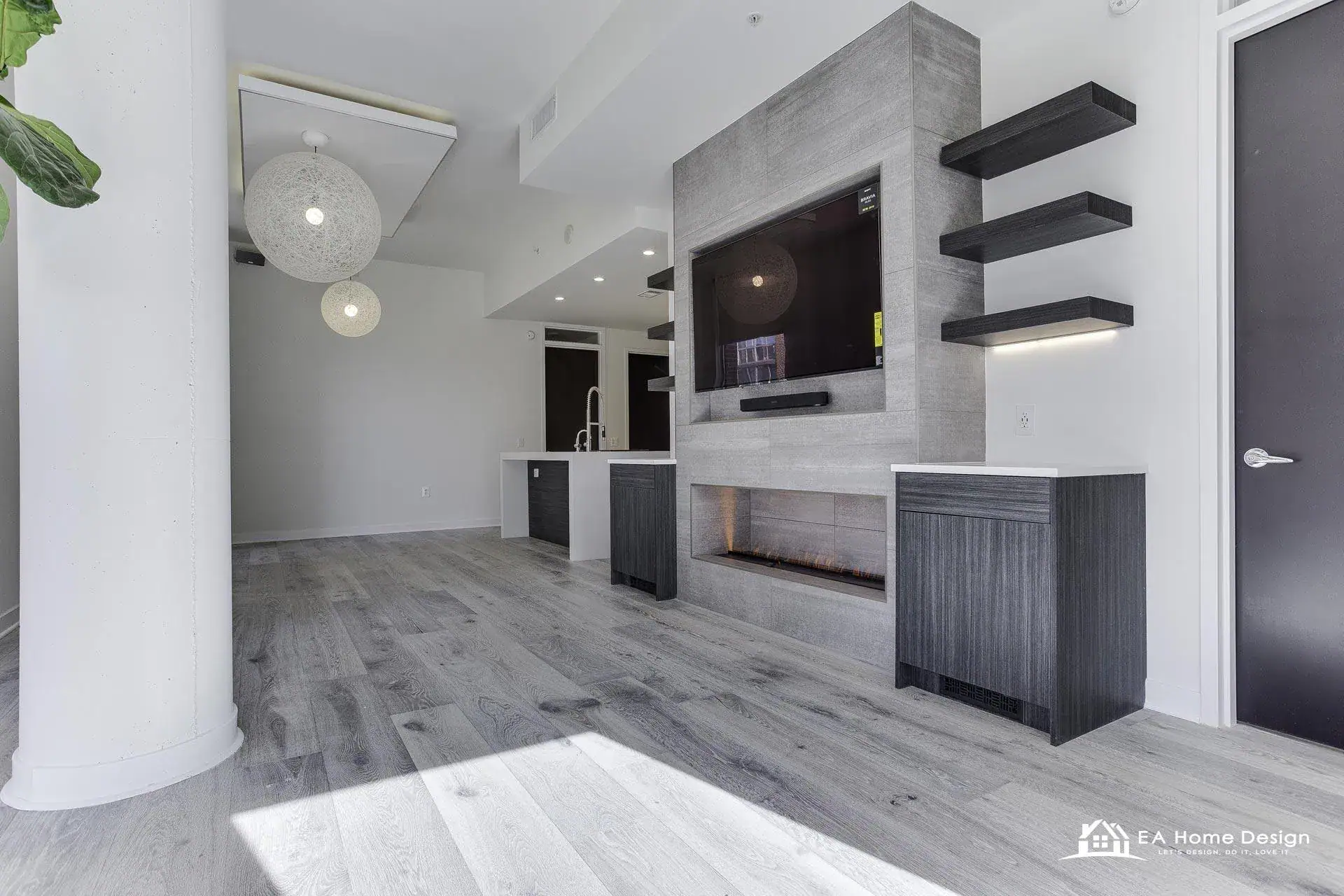 Living area with a full-height tile media wall and a mounted television in a Fairfax County home remodeled by EA Home Design