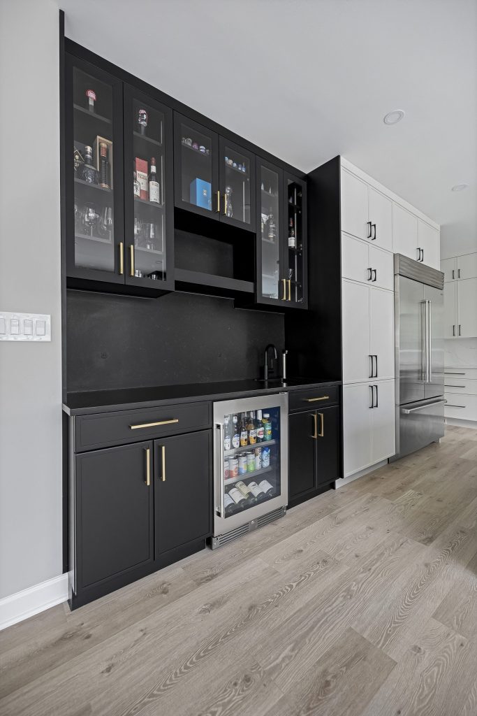 Mixed metals design with gold hardware on black cabinets and stainless accents
