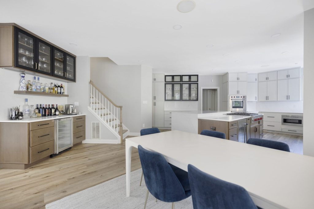 Open kitchen and dining area with a wet bar and a white island in a remodeled Fairfax County, VA home