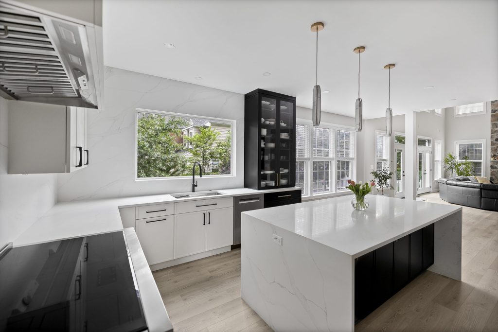 White kitchen with a spacious island and pendant lights in a remodeled Northern Virginia home
